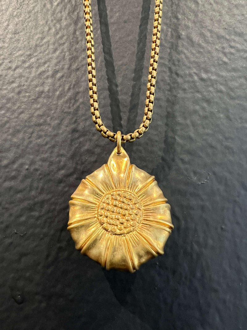 A medium handblown borosilicate glass eye caged in a vintage brass sunflower stamping  by Pake